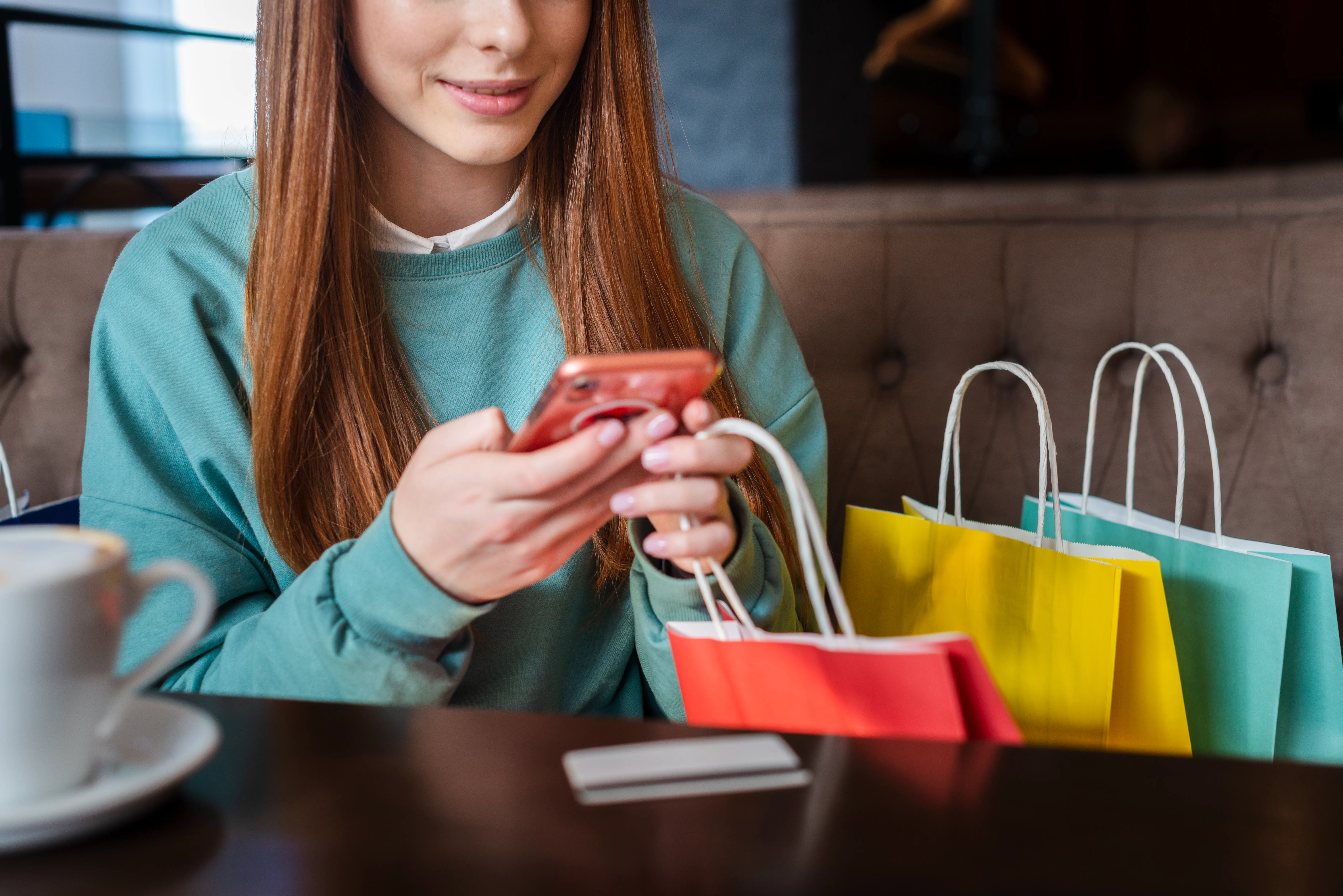 Red-haired woman checking her phone after shopping
