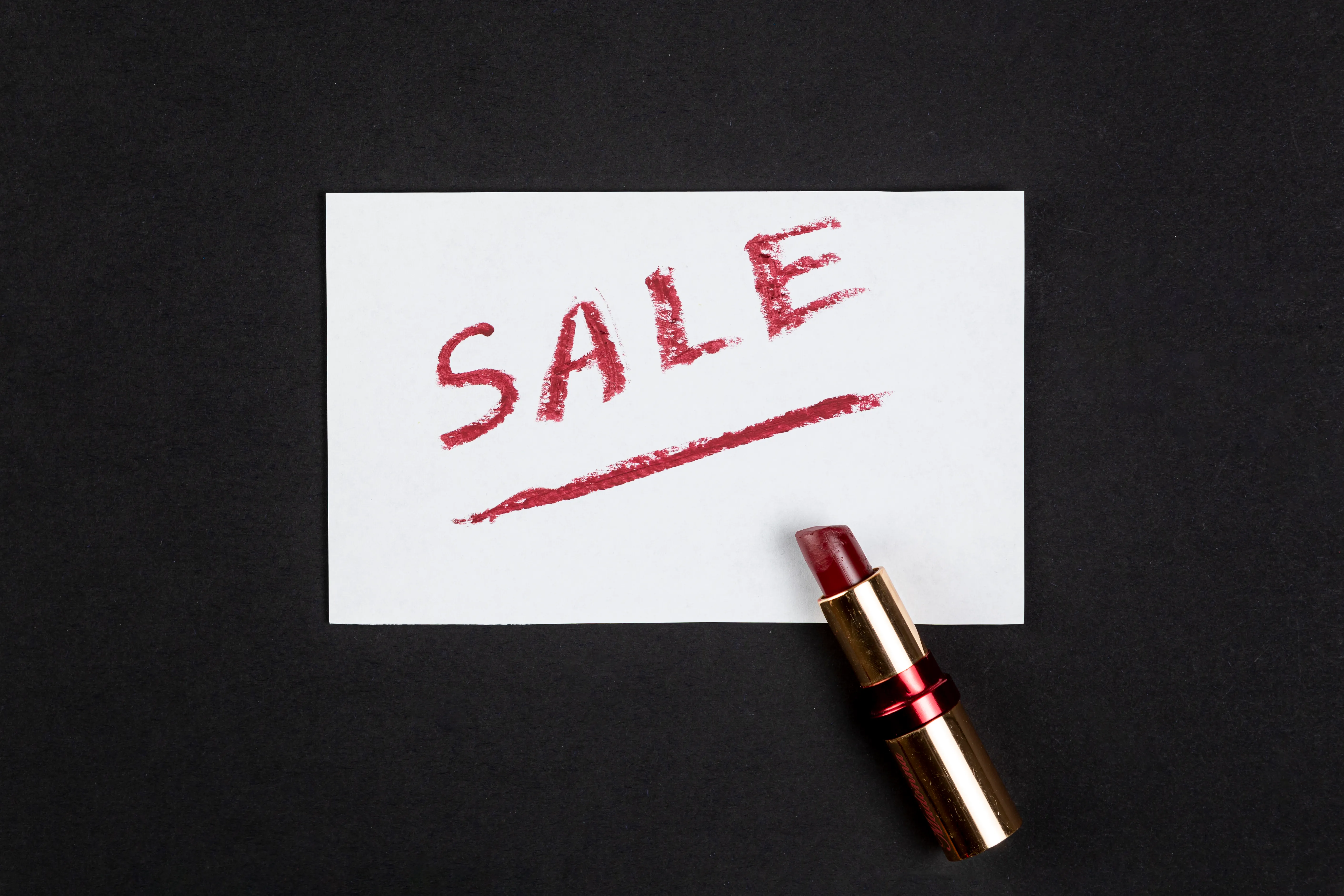 there is a white paper with SALE written on it on the black table