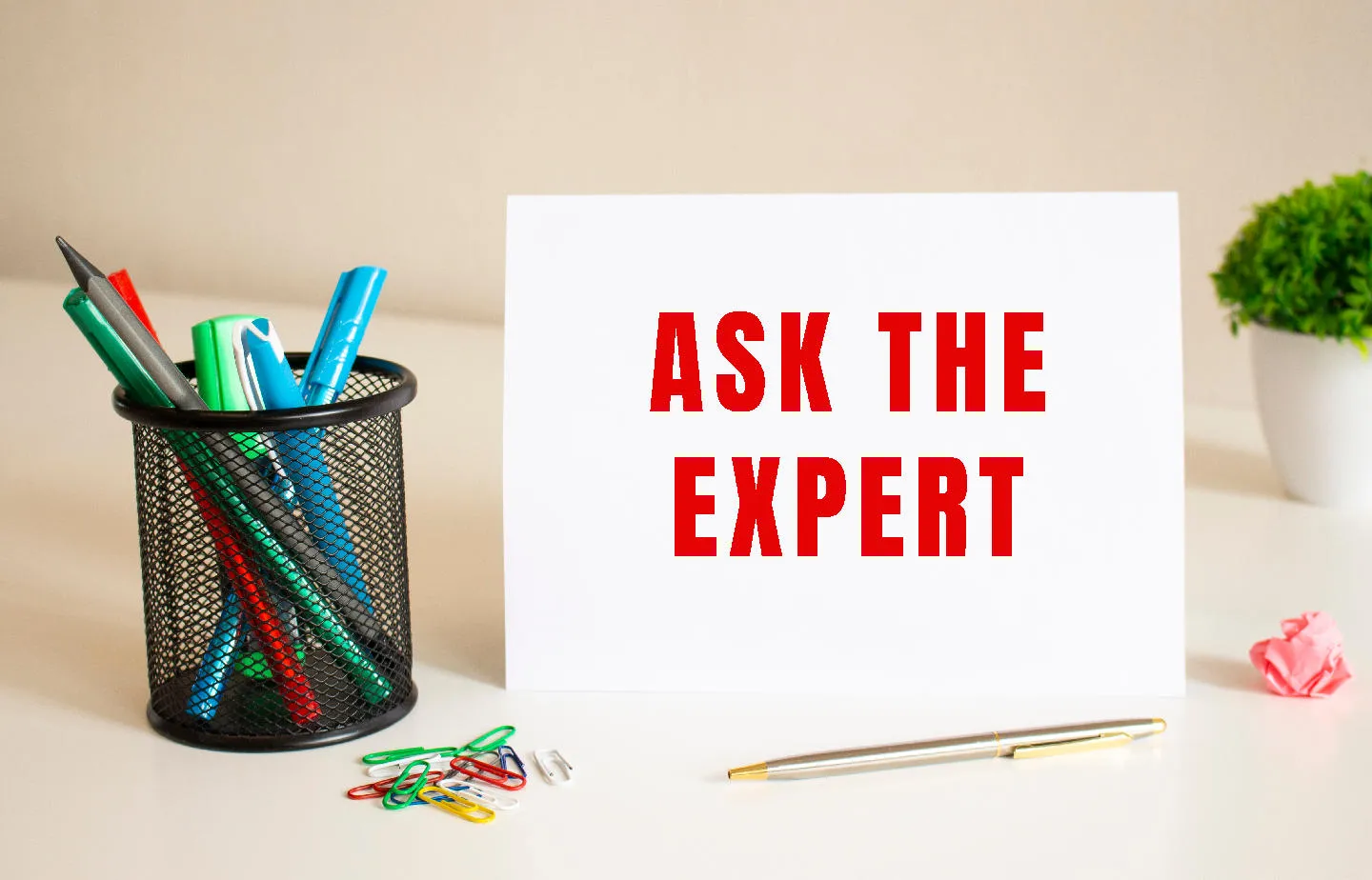 Sign saying "Ask the Expert" with pen holder.