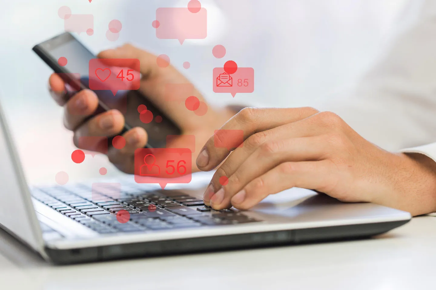 Hands using phone and laptop with social icons